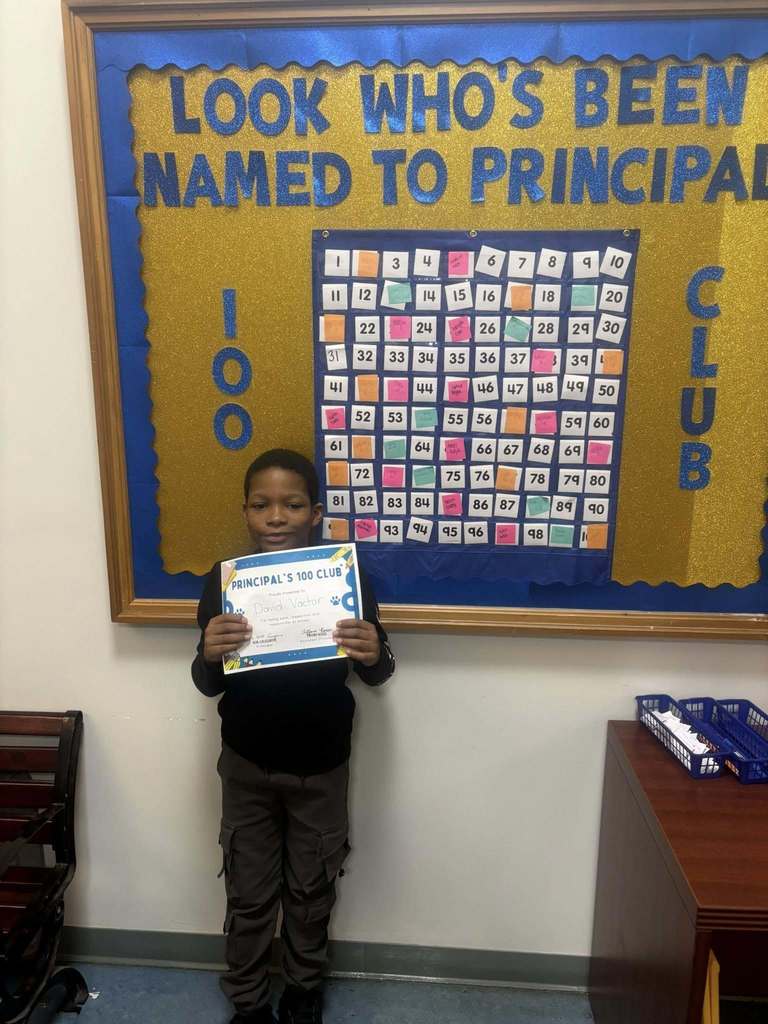 A student holding their "Principal 100 Club" certificate. 