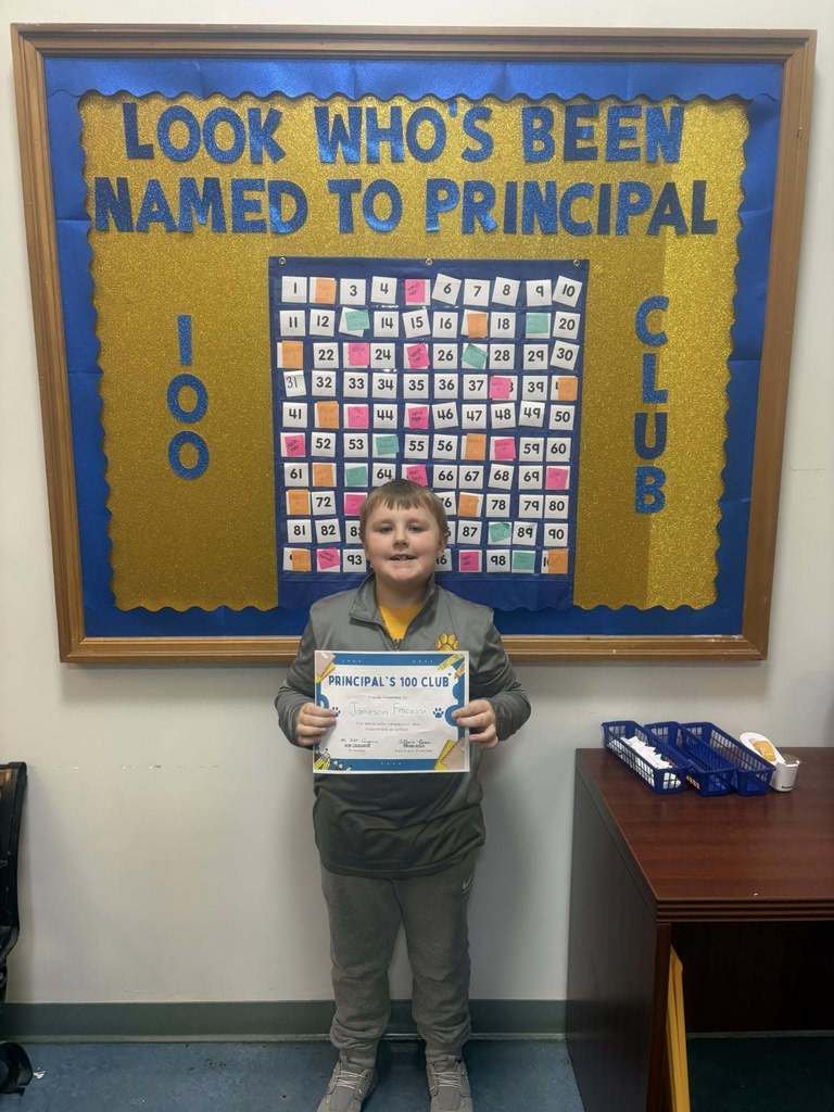 A student holding their "Principal 100 Club" certificate. 