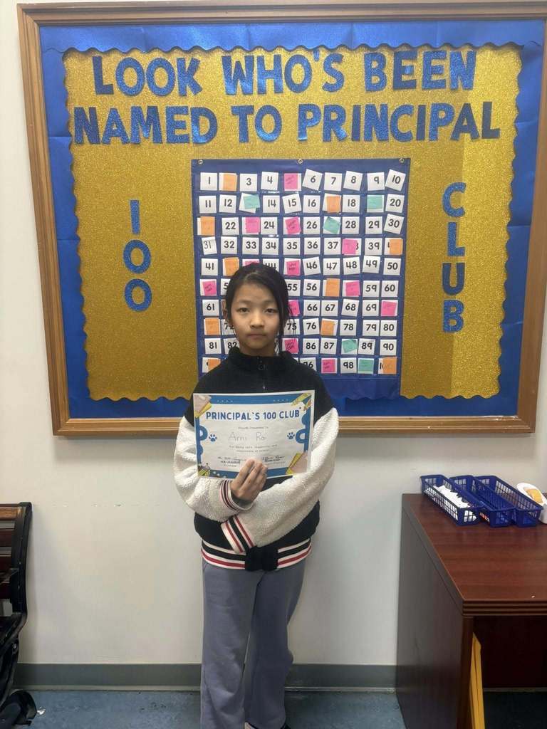 A student holding their "Principal 100 Club" certificate. 