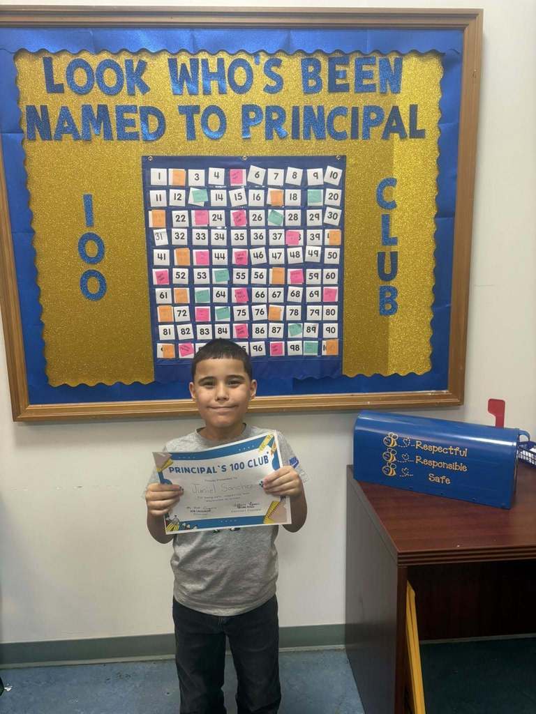 A student holding their "Principal 100 Club" certificate. 