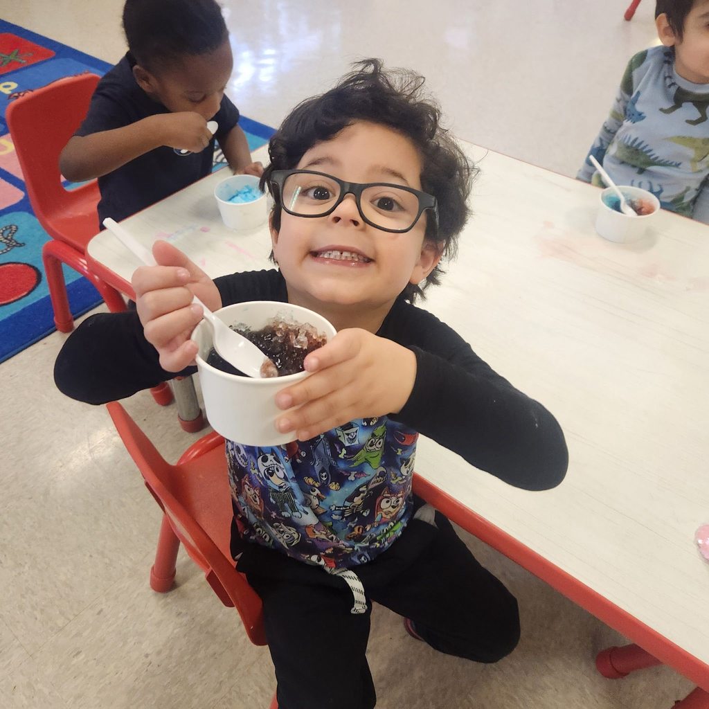 Student eating his snow cone and smiling. 