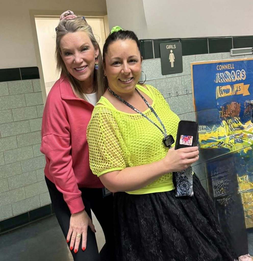 Two teachers dressed in bright 80s clothing. 
