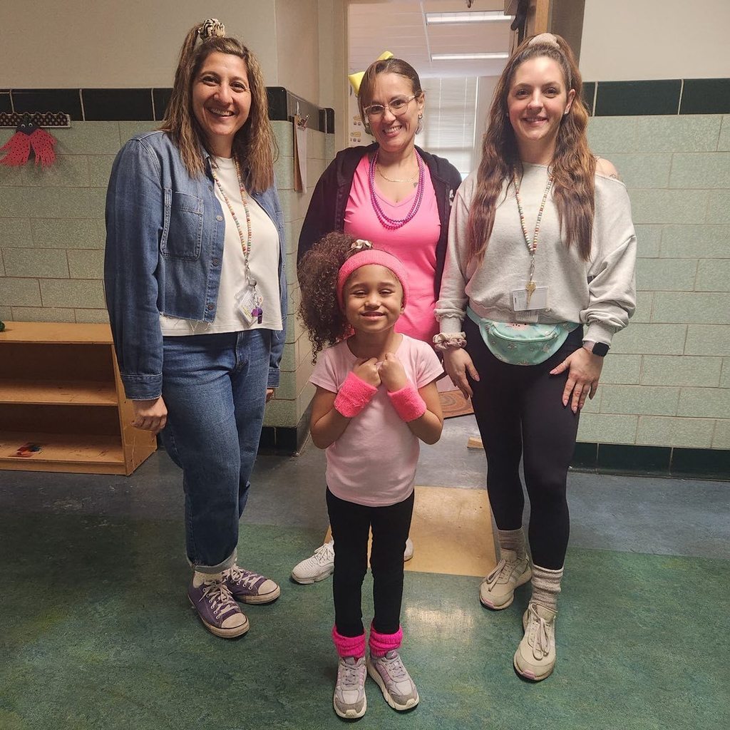 Teachers and student dressed in bright 80s clothing. 