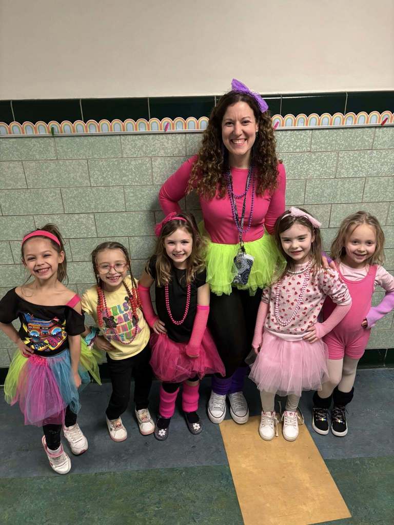 Teacher and students dressed in bright 80s clothing. 