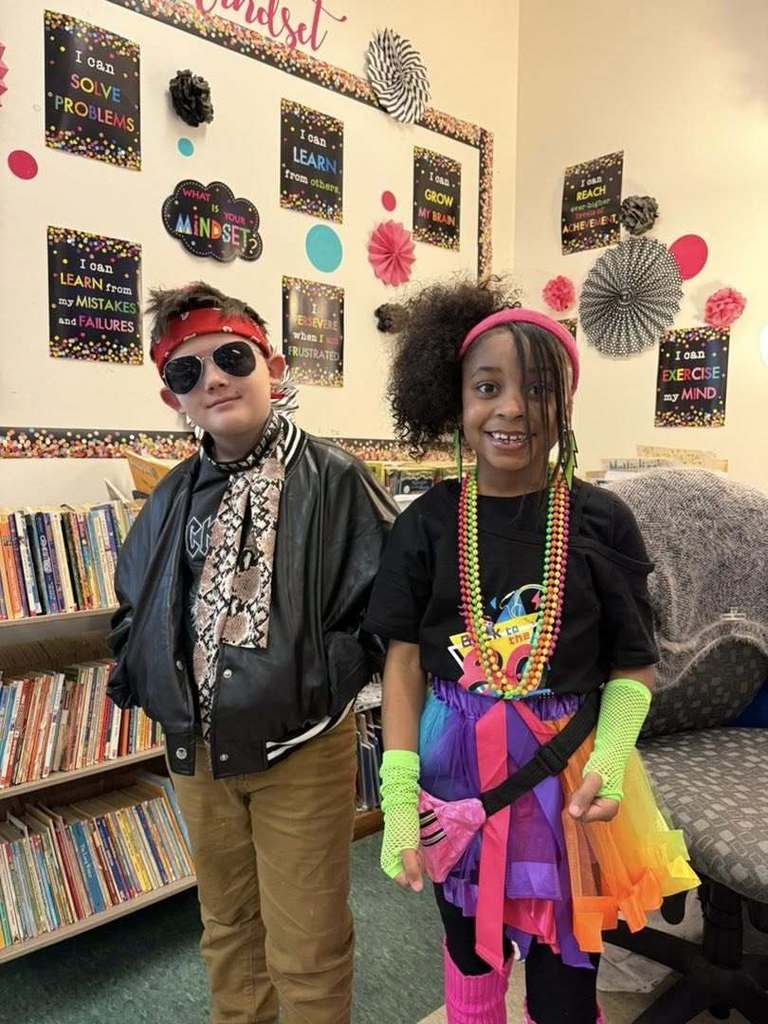 Two students dressed in 80s clothing. 