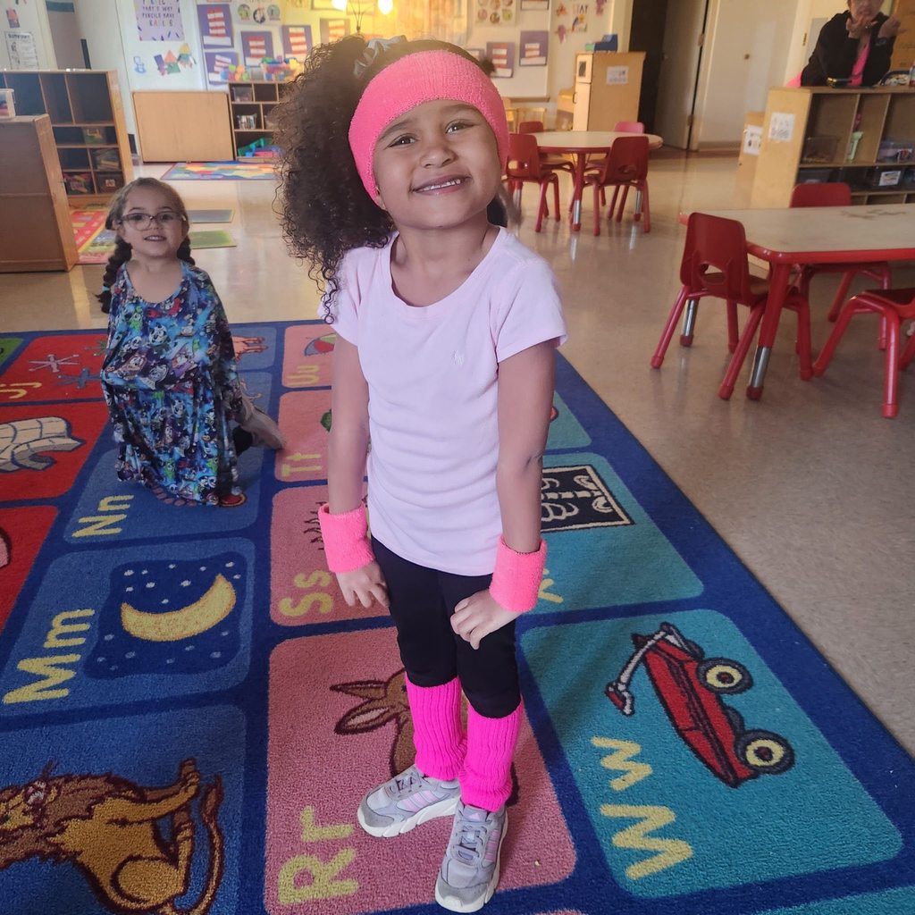 Young girl dressed in bright pink 80s outfit. 