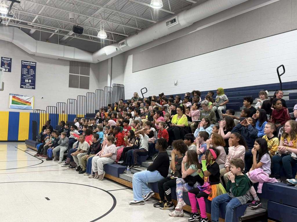 Students and teachers sitting on bleachers. 