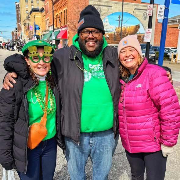 A women and man wearing green for St. Patrick's Day and a women wearing a pink jacket. 