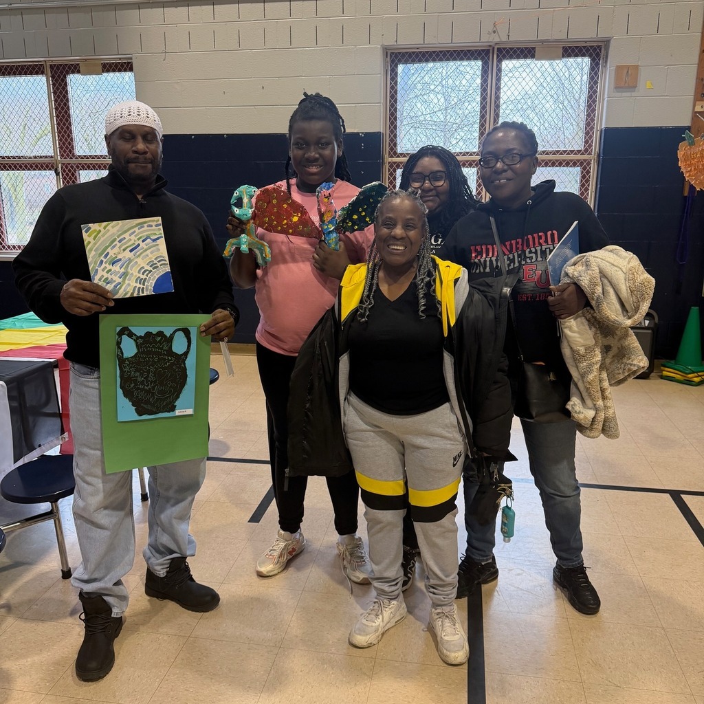 Students and adults holding art. 