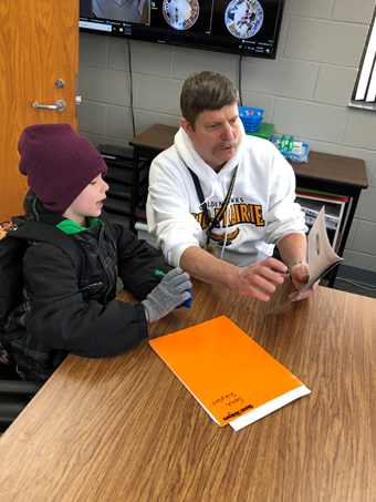 Superintendent Mark Schneider reads with a student