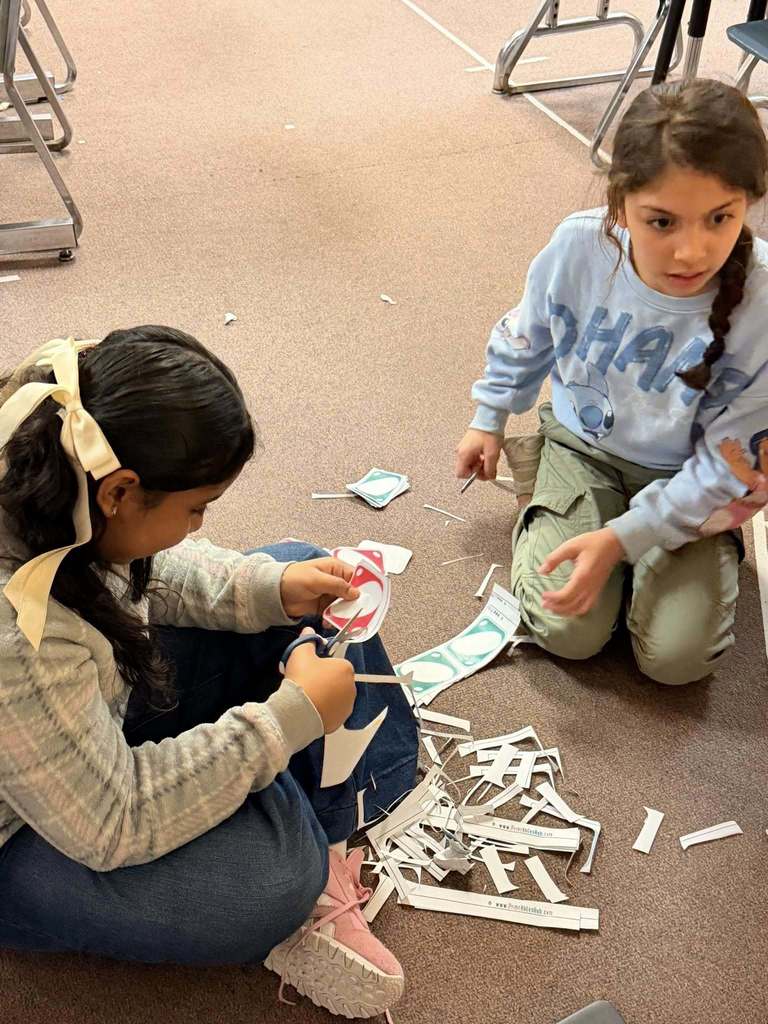 Students cutting blank Uno Card that are printed on paper. 