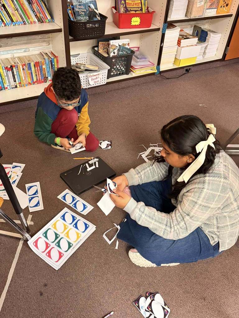 Students cutting blank Uno Card that are printed on paper. 
