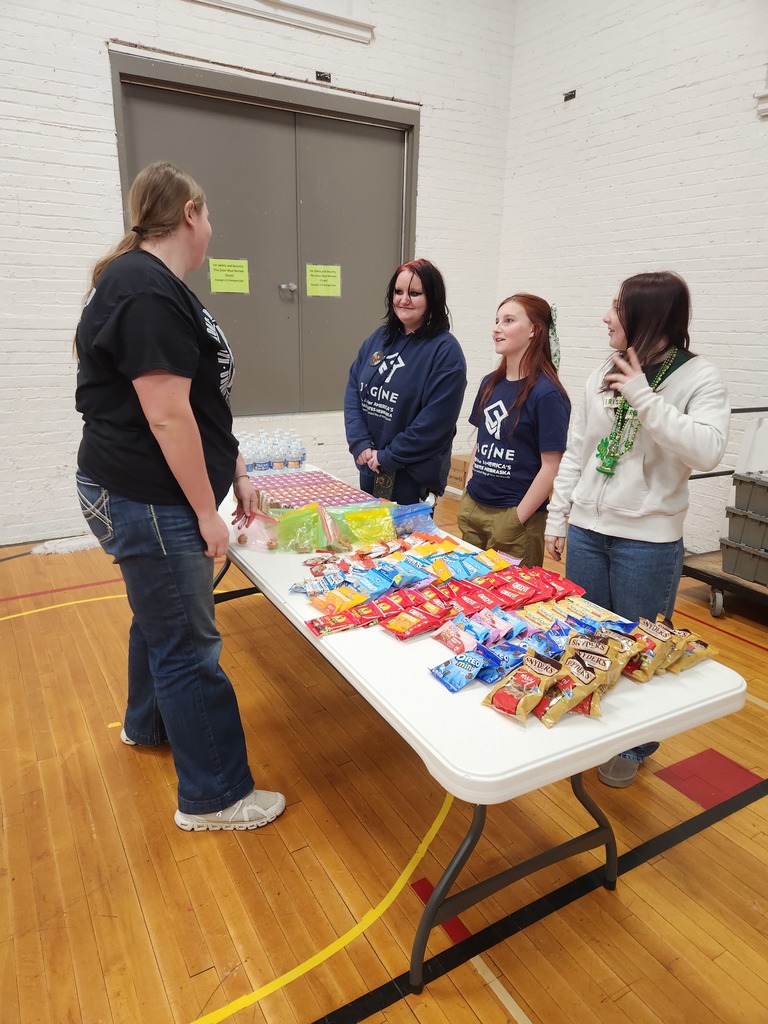 3 students offering refreshments to a generous blood donor at the school sponsored blood drive.