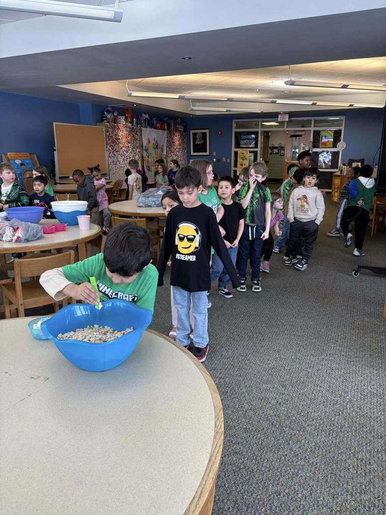 Students waiting in line to play a game using lucky charms cereal. 