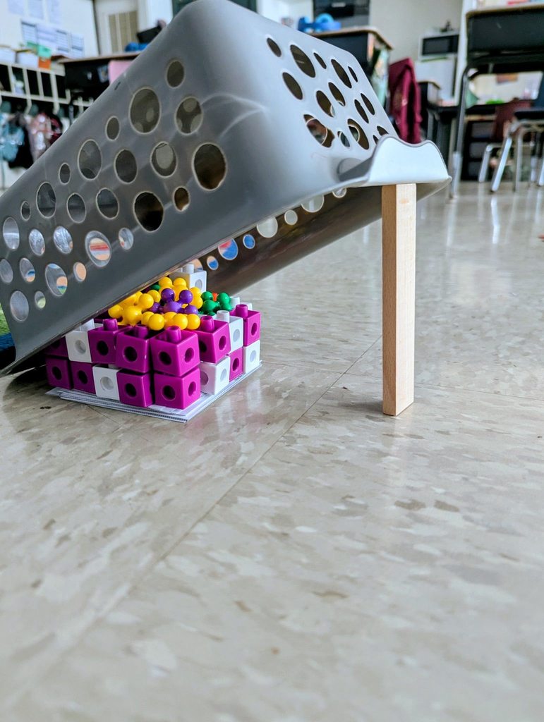 A trap students made to catch the leprechaun, using colorful blocks, a basket, and a stick. 