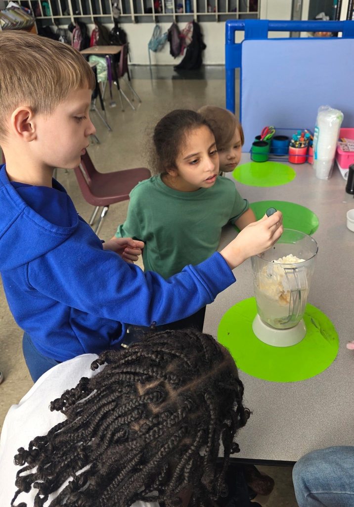 A student adding ingredients into the blender to make a shamrock shake. 