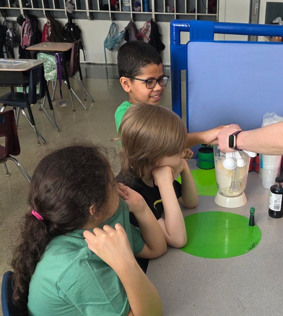 Students helping make a shamrock shake. 
