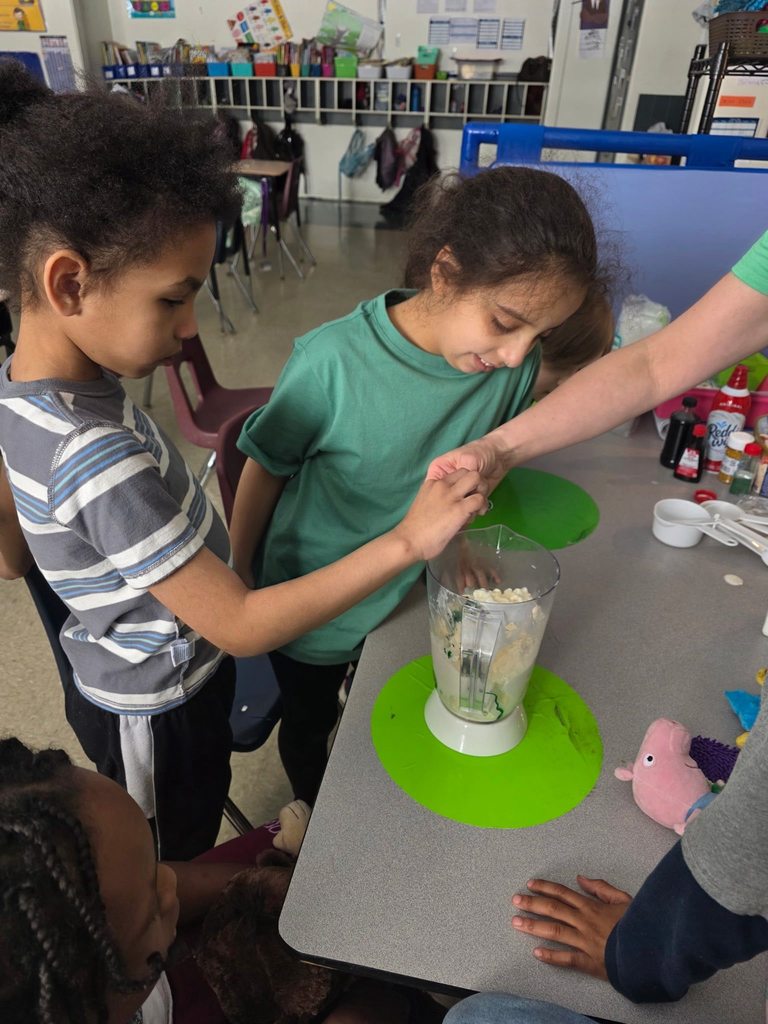A student is helping a teacher add food coloring to the blender. 