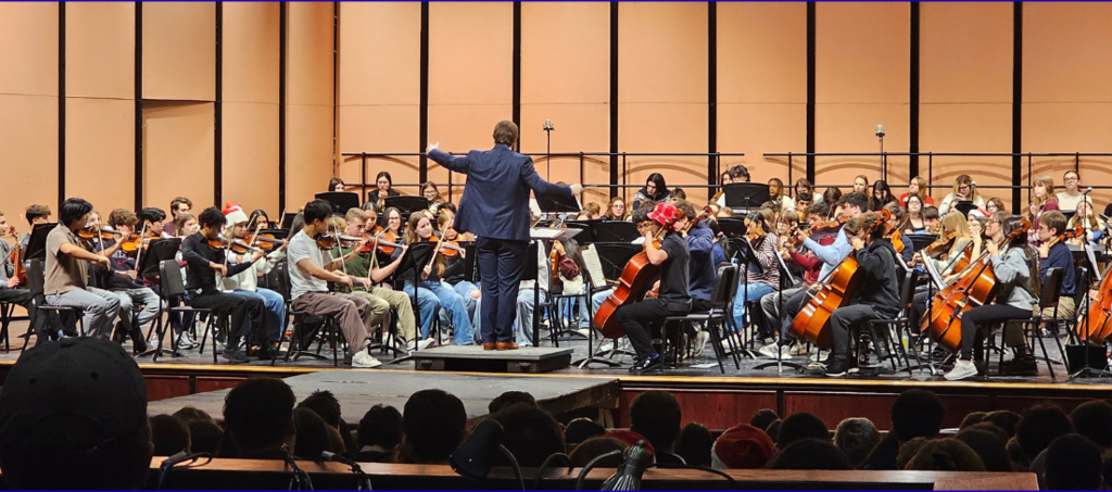 Student orchestra performing with a conductor