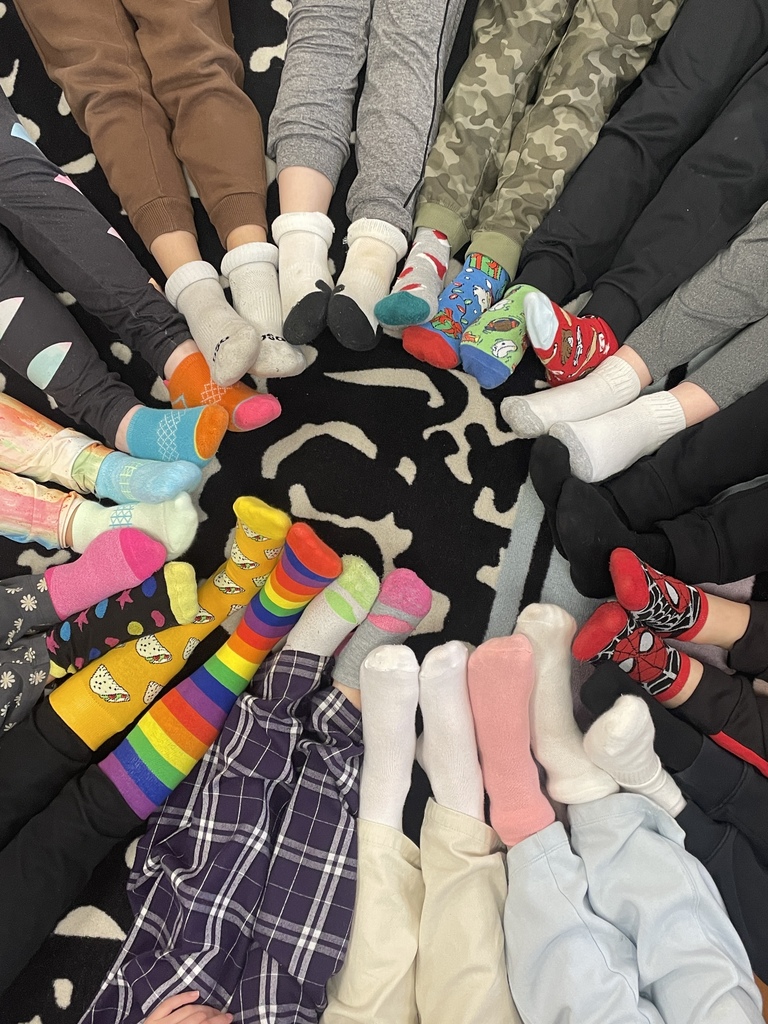 Students sitting in a circle with mismatched socks on.