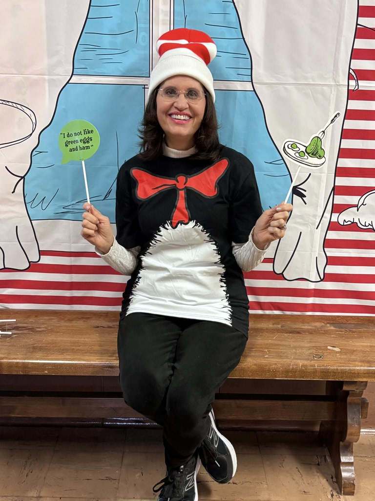 A teacher dressed as the cat in the hat. 