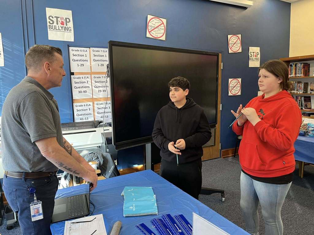 Students in a library talking to staff from National Fuel at a table. 