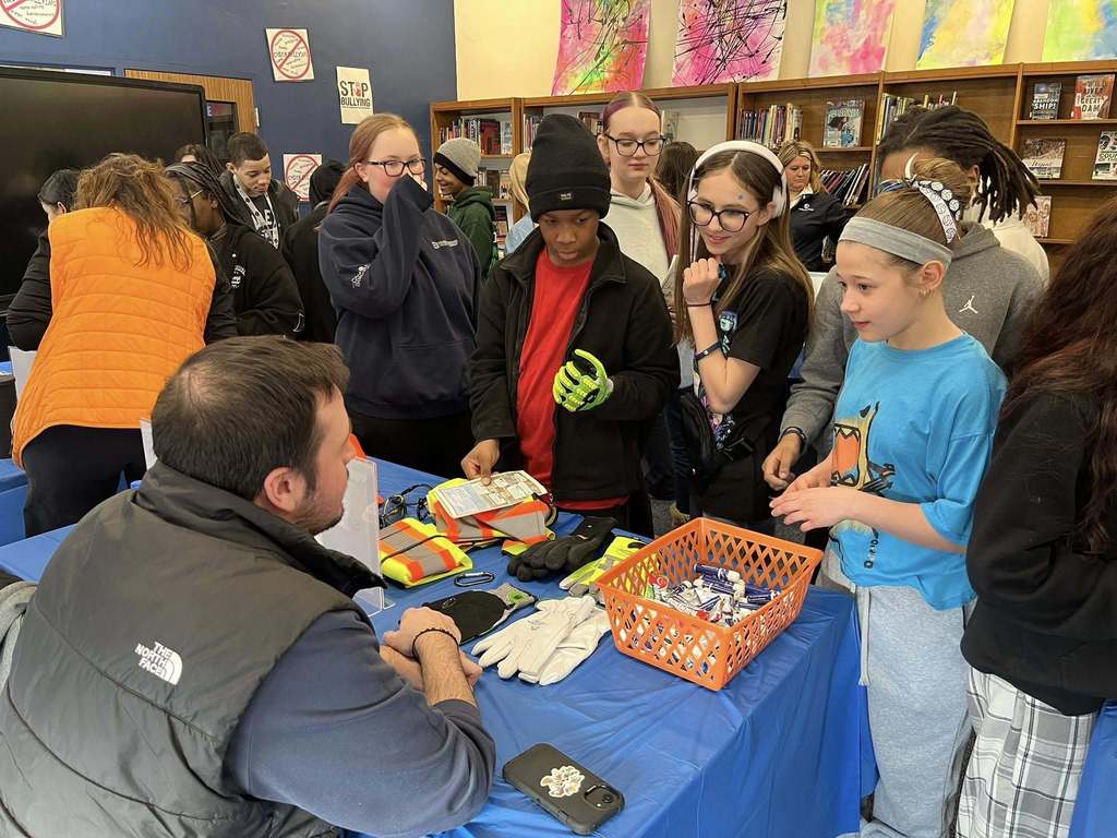 Students in a library talking to staff from National Fuel at a table. 