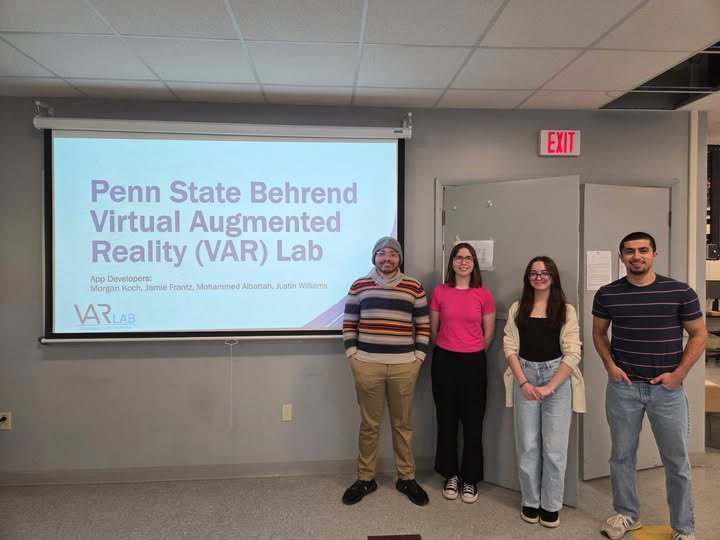 Students standing in front of a projector screen that says "Penn State Behrend Virtual Augmented Reality (VAR) Lab. 
