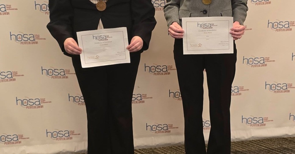 Two students holding their HOSA awards. 