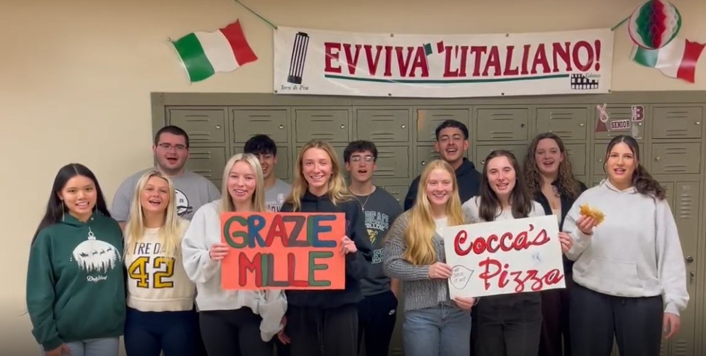 Students with graze mille signs to cocca's pizza