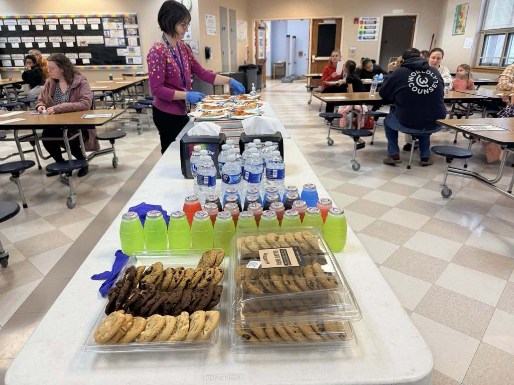 Food and drinks on a long table in a cafeteria. 