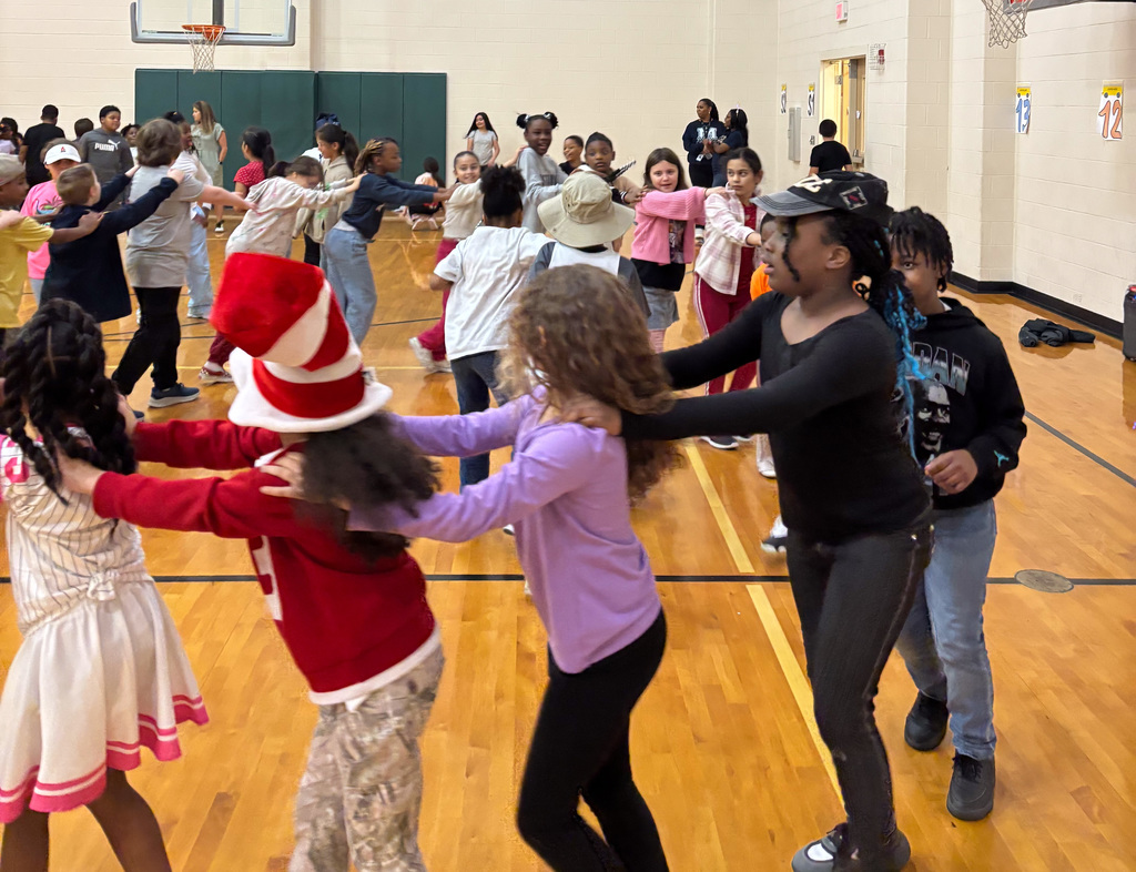 students in a large conga line in the gym