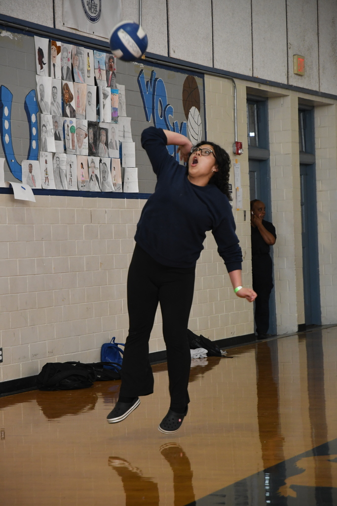 girl serving a volleyball