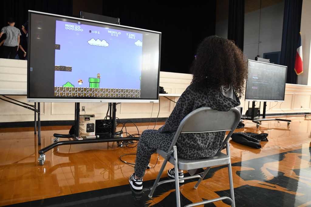 girl playing super mario in a school gym