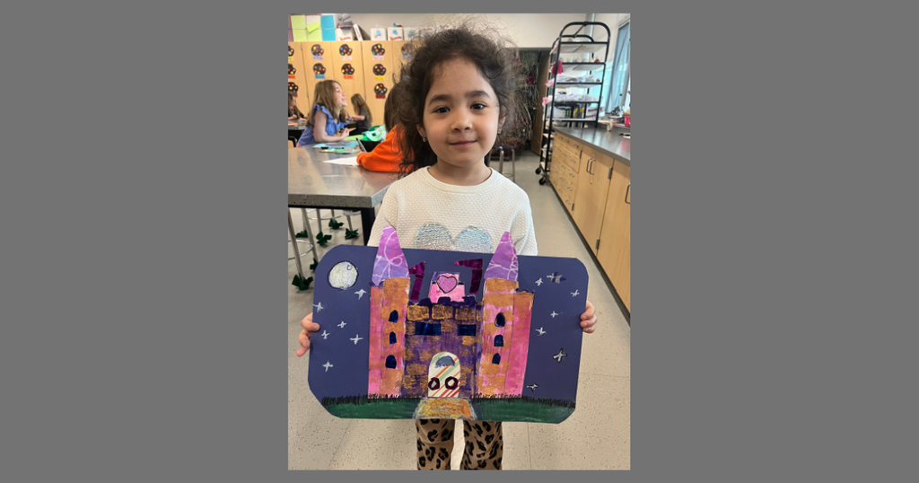 student displaying her castle art work