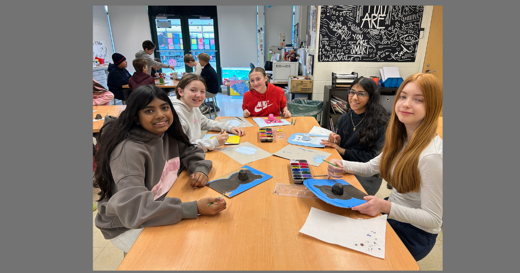 group of students looking at the camera while working on 3D art