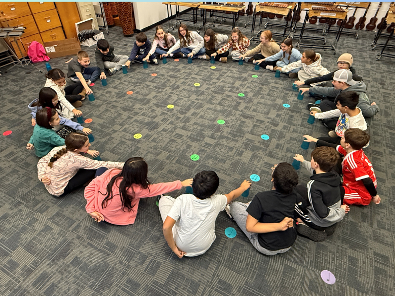 students sitting in a circle playing a music game