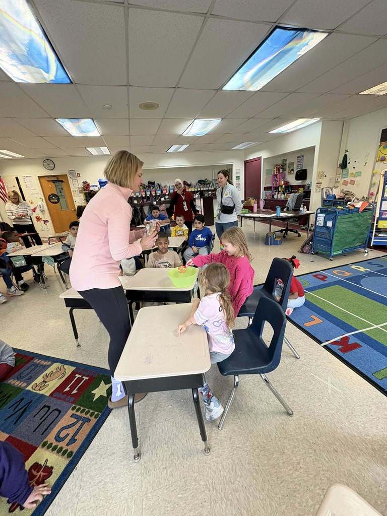 A teacher helping her students prepare to make popcorn. 