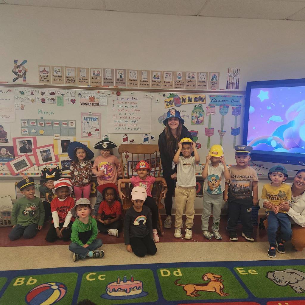 Students and a women wearing fun hats. 