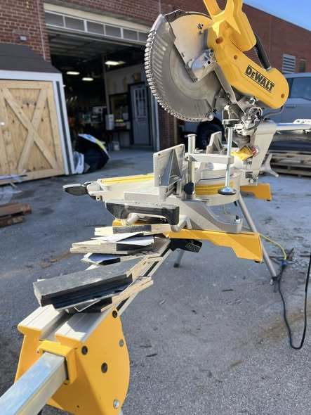 A yellow saw machine outside. 