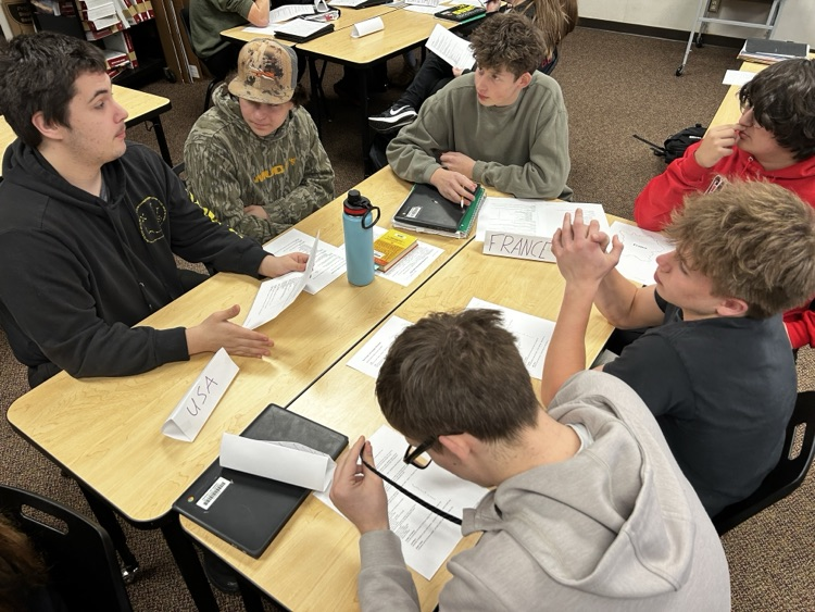 students sitting in groups, talking together
