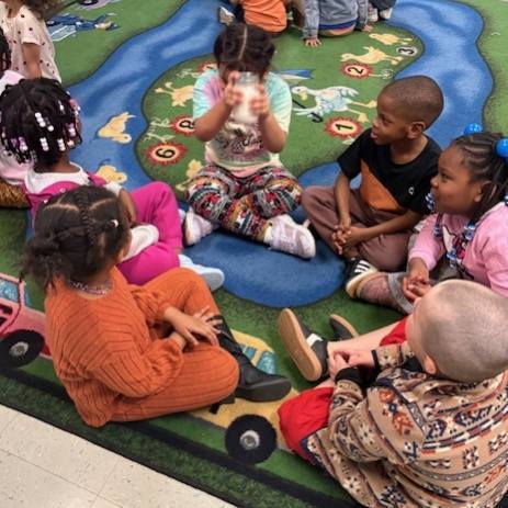 Kids shaking the ingredients in a mason jar to make butter. 