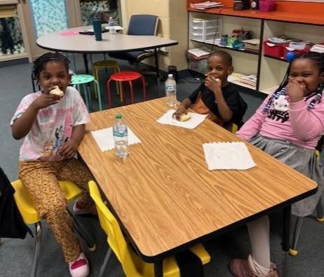 Kids eating bread with butter on it. 