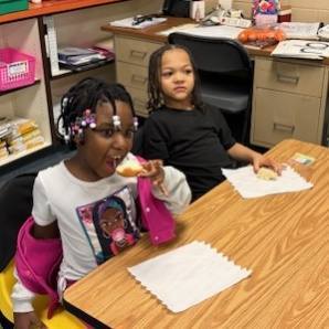 Kids eating bread with butter on it. 
