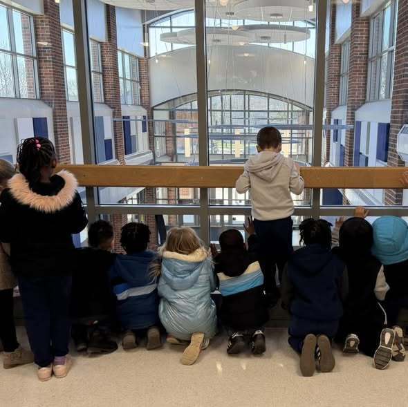 Students looking out the window at the New Edison Building. 