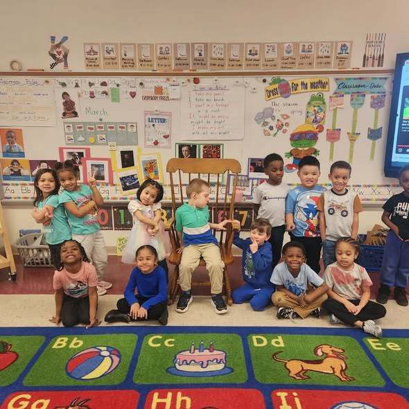 Students wearing blue in a classroom and posing. 