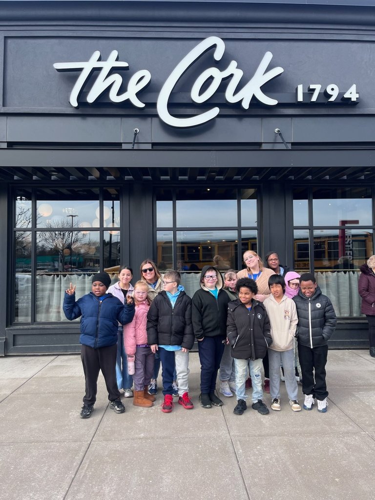 Students and staff standing in front of the Cork restaurant. 