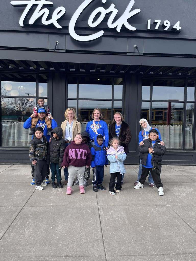 Students and staff standing in front of the Cork restaurant. 