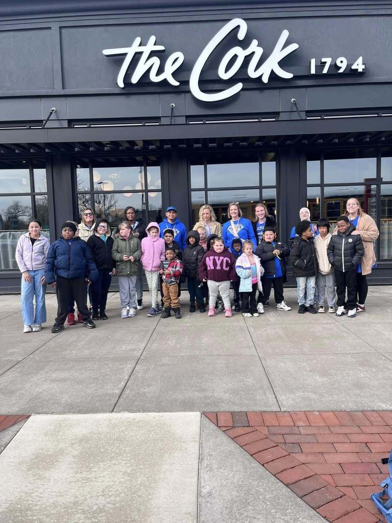 Students and staff standing in front of the Cork restaurant. 