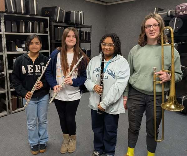 Students holding musical instruments. 